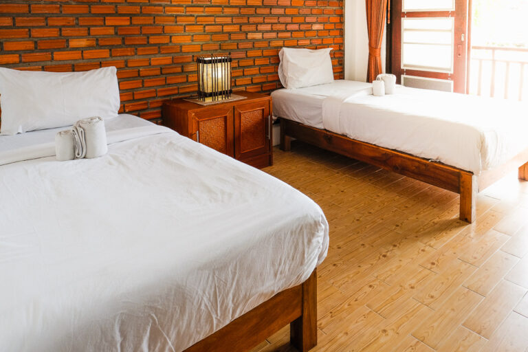 Twin beds in a superior room with brick walls.