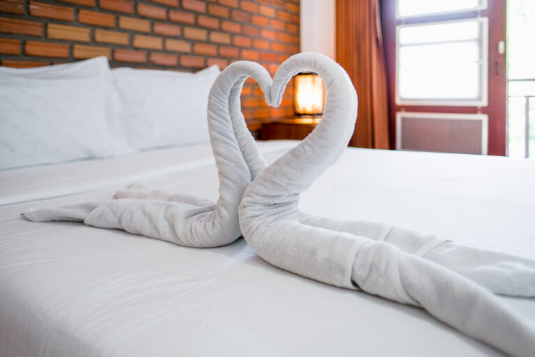 Two towels rolled into swans making a heart shape.