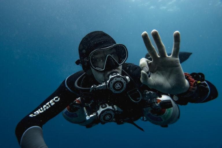 Diver in sidemount configuration giving the OK signal.